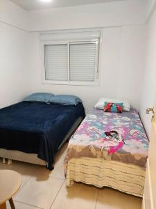 um quarto com 2 camas ao lado de uma janela em Apartamento pé na areia e piscina em Capão da Canoa
