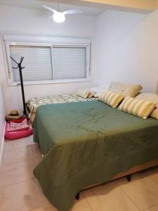 een slaapkamer met 2 bedden en een raam bij Apartamento pé na areia e piscina in Capão da Canoa