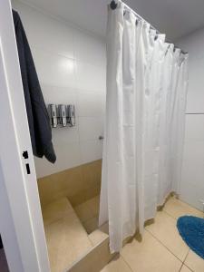 a shower with a white shower curtain in a bathroom at Mendoza Your Apart in Mendoza