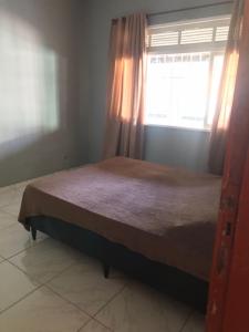een slaapkamer met een bed met een raam en een raam bij CASA GRIEBELER 02 in Cabo Frio