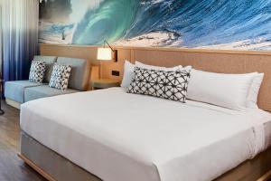 a bedroom with a bed and a painting of a wave at Turtle Bay Resort in Kahuku