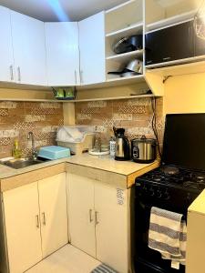a kitchen with white cabinets and a stove top oven at 2 Bedroom townhouse in Bacolod City in Bacolod