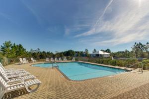 a swimming pool with two lounge chairs and a swimming pool at Serene Hideaway in Gulf Shores
