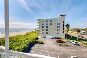 a building with cars parked in front of the beach at Turtle Time Suite in Satellite Beach
