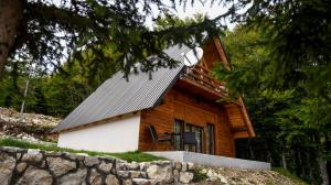 uma cabana de madeira com um telhado de metal em Highlander guesthouse em Žabljak