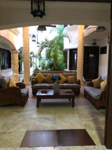 a living room with couches and a coffee table at Hotel Boutique Villas Segovia Cozumel in Cozumel