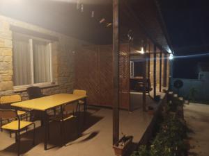 een tafel en stoelen op een patio in de nacht bij Avcı Pansiyon in Gokceada Town