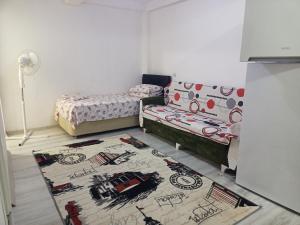 een slaapkamer met 2 bedden en een tapijt op de vloer bij Avcı Pansiyon in Gokceada Town
