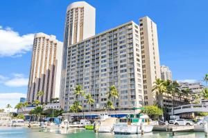 a large building with boats docked in a marina at Newly Renovated Ilikai Marina Studio - Near Beach! in Honolulu