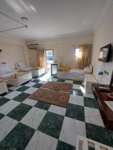 Großes Zimmer mit 2 Betten und einem Schachbrettboden in der Unterkunft Delmon Hotel in El-Tor