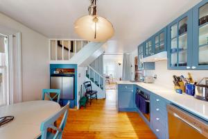 una cocina con armarios azules y una escalera en The Bean House Upstairs and Downstairs Unit en Camden