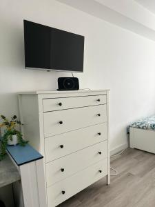 a white dresser with a television on top of it at High Barnet Studio Flat in Barnet