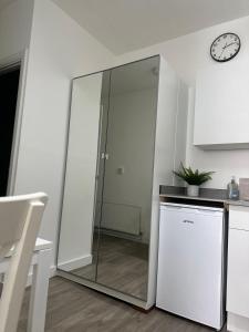 a glass door in a kitchen with a dishwasher at High Barnet Studio Flat in Barnet