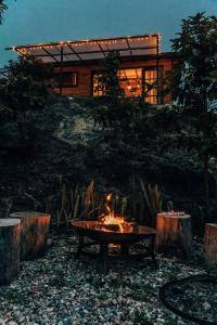a fire pit in front of a log cabin at Jardín Satori Glamping in Piedecuesta +27 photos