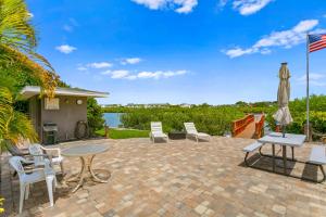 een patio met stoelen, een tafel en een vlag bij Sea Shell 44 in Clearwater Beach