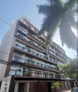 een appartementencomplex met een palmboom ervoor bij Lujoso depto. en Equipetrol in Santa Cruz de la Sierra