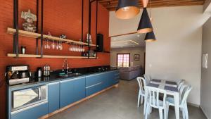 uma cozinha com armários azuis e uma mesa com cadeiras em House Interlagos em São Paulo