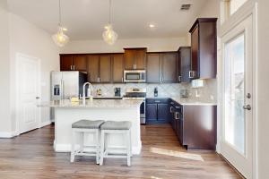 une cuisine avec un grand îlot avec deux tabourets dans l'établissement Balanced at Brachetto, à San Antonio