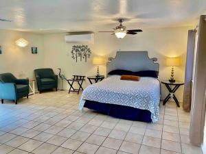 a bedroom with a bed and two chairs and a ceiling fan at Crane Suite Hot Tub Bbq King Bed- Sleeps 4 in Ahwahnee