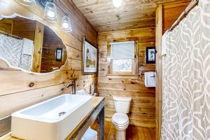 a bathroom with wooden walls and a sink and a toilet at Buck Haven in Murphy +27 photos