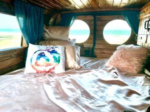 a bed in a room with two windows at Camper Van Hawaii in Kaneohe