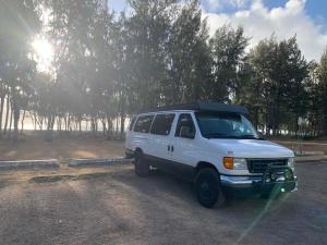 ein weißer Van auf einer unbefestigten Straße geparkt in der Unterkunft Camper Van Hawaii in Kaneohe