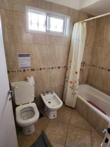 a bathroom with a toilet and a sink and a tub at El Desafío in Santa Ana