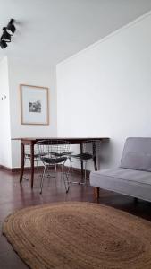 uma sala de estar com um sofá, uma mesa e um piano em Luminoso Depto con 2 Habitaciones y Cocheras - Meridiano Alquiler Temporario em La Plata