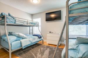 a bedroom with two bunk beds and a tv at Super Fun House in Perfect Location in San Antonio