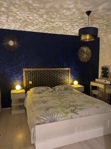 een slaapkamer met een groot bed met een blauwe muur bij Maison Lyon-Bron Eurexpo - Stadium Groupama in Bron