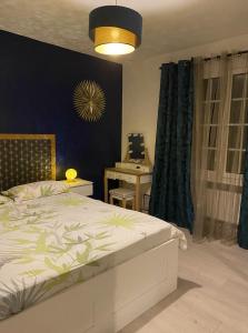 een slaapkamer met een bed en een blauwe muur en een tafel bij Maison Lyon-Bron Eurexpo - Stadium Groupama in Bron