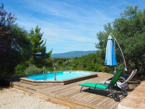 einen Pool mit Sonnenschirm und Stuhl in der Unterkunft Nice house with private pool in the Parc du Luberon, Grambois in Grambois