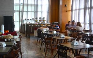 een groep mensen die aan tafel zitten in een restaurant bij Suítes Natal Plaza - Apto 1812 in Natal