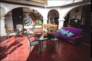 a living room with a purple couch and tables and chairs at Ñanderoga B&B in Corrientes