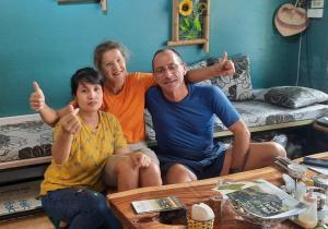 three people sitting on a couch giving thumbs up at Golden Bell Backpacker Hostel in Ninh Binh