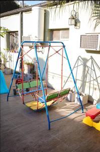 a swing set in a yard with a playground at Ñanderoga B&B in Corrientes
