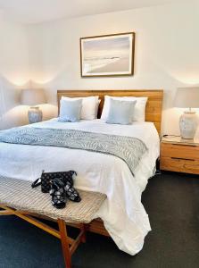 a bedroom with a large bed with shoes on a bench at The Waterfront Apartment in Port Fairy