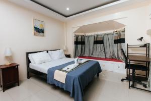 Schlafzimmer mit einem Bett, einem Schreibtisch und einem Stuhl in der Unterkunft Bahay Ni Kikay Vacation Rental - WiFi Included in General Santos