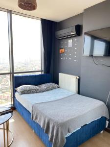 a bedroom with a blue bed with a flat screen tv at Ikon Suit in Istanbul