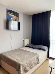 a bedroom with a bed with a television on the wall at Ikon Suit in Istanbul