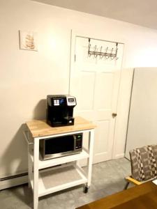 a microwave on a white table in a room at Glorious Suite near Downtown with washer/dryer in Gloucester