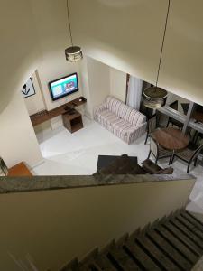 a living room with a couch and a tv at COBERTURA DUPLEX 70 m COM HIDRO NO MELHOR HOTEL DE TAGUATINGA in Taguatinga