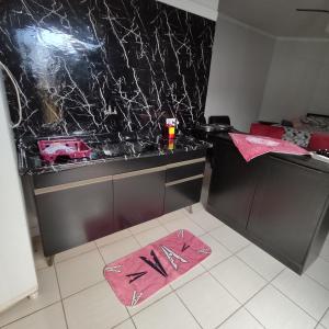 een keuken met een aanrecht met een roze handdoek op de vloer bij Kitnet próximo ao parque exposições in Maringá