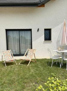 two chairs and a table in the grass next to a building at Studio indépendant in Marigny-Saint-Marcel