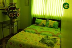 Dormitorio verde con cama y mesa con flores en HOTEL REY DE ORO, en Chiclayo