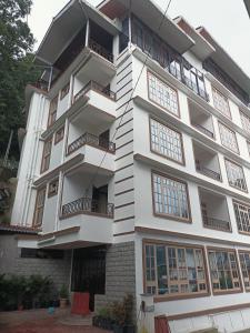 ein weißes Gebäude mit Balkonen darauf in der Unterkunft HOTEL ANGS RETREAT in Gangtok