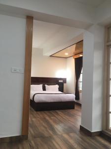 甘托克的住宿－HOTEL ANGS RETREAT，一间卧室配有一张床,铺有木地板