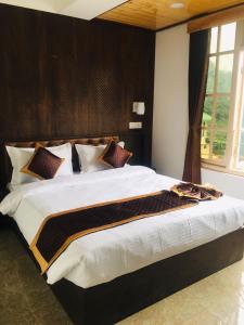Schlafzimmer mit einem großen Bett mit einem Kopfteil aus Holz in der Unterkunft HOTEL ANGS RETREAT in Gangtok