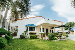 a white house with a palm tree in the yard at Bahay Ni Kikay Vacation Rental - WiFi Included in General Santos