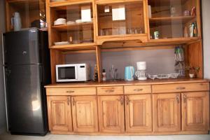 a kitchen with wooden cabinets and a refrigerator at Ruhuka House - connexion STARLINK privée & gratuite in Bujumbura